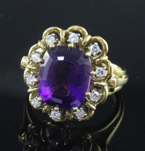 A modern 18ct gold, amethyst and diamond set oval dress ring, size O.